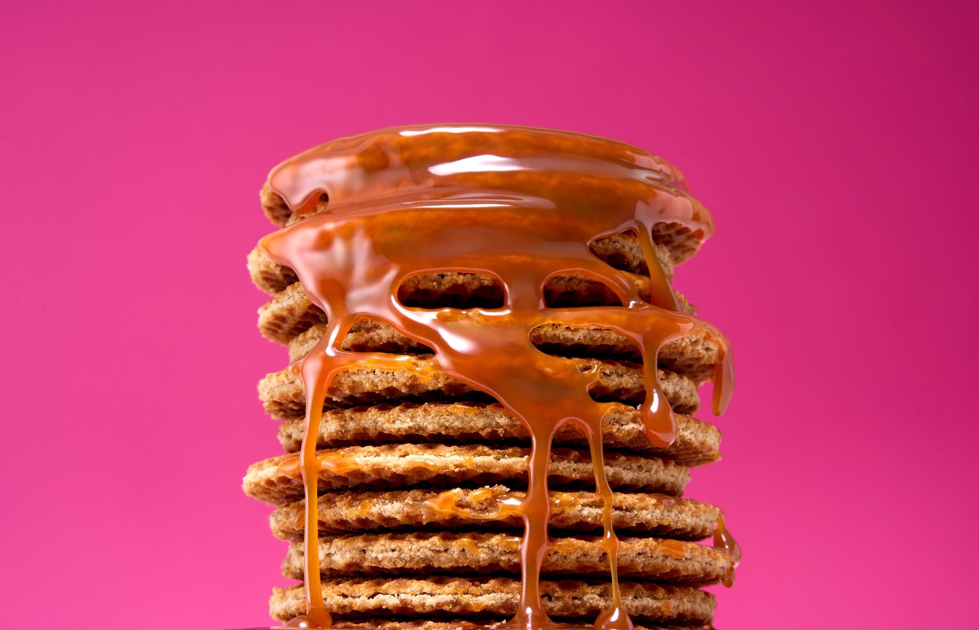 Stack of stroopwafels with caramel drip on pink