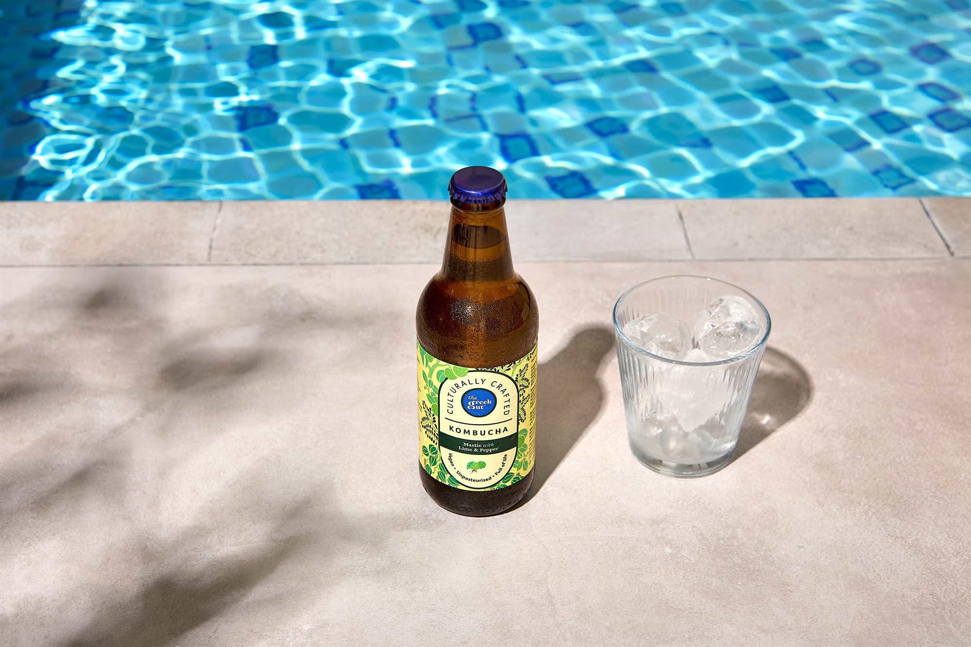 The Greek Gut Mastic Lime and Pepper kombucha by a swimming pool