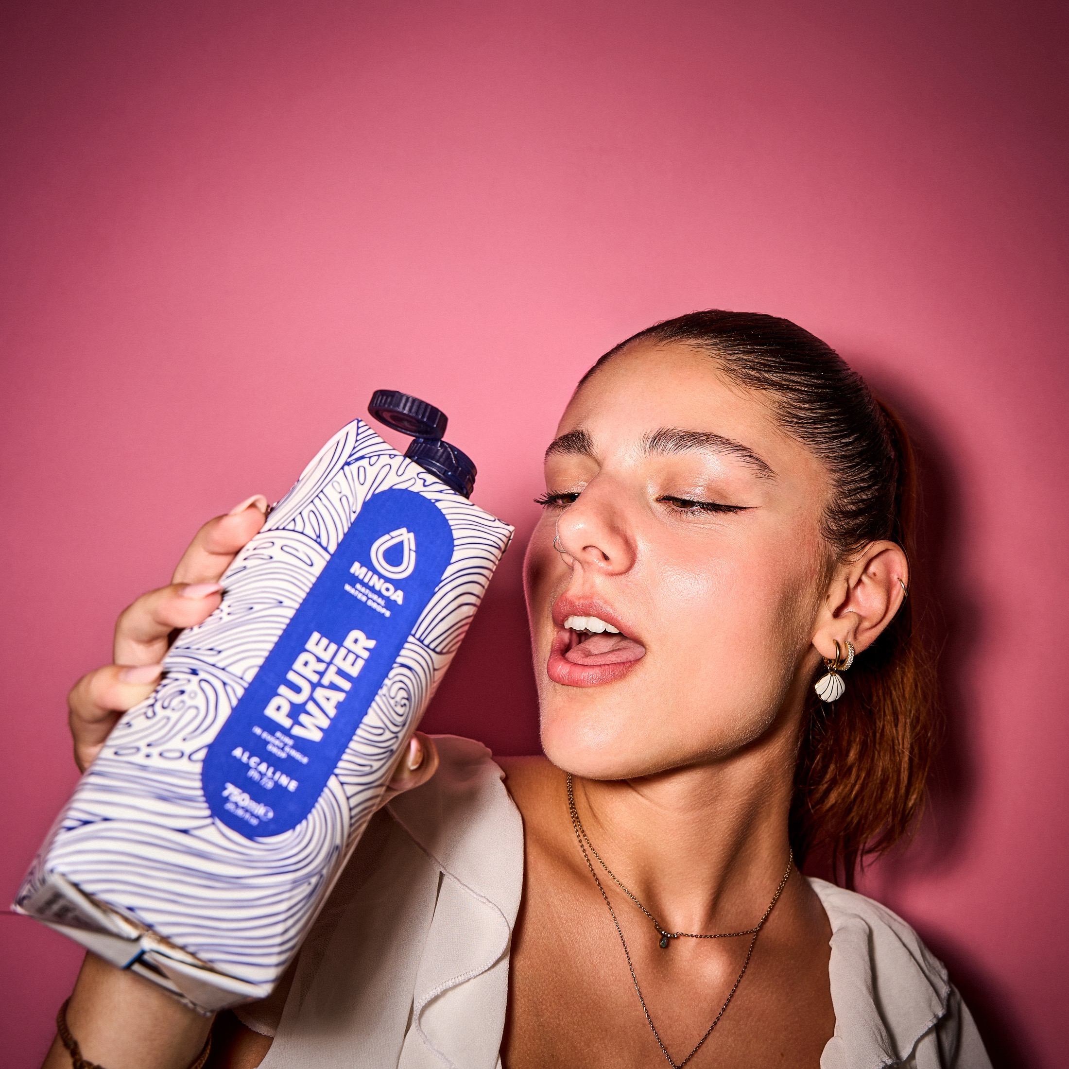 Minoa Pure Water lifestyle portrait with pink background